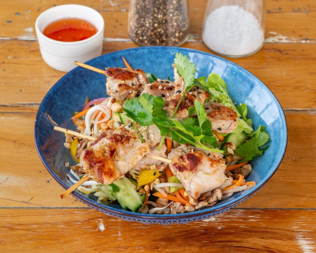 Vietnamese chicken salad with lemongrass chicken skewers, herbs and peanuts